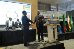 Outgoing ZAMCOM Chair (right), Hon Alpheus !Naruseb handing over Shield to Tanzania's Deputy PS Eng Emmanuel Kalobelo_